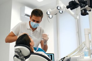 Dentist discussing Canadian Dental Care Plan CDCP coverage and treatment options with a patient during a dental consultation.