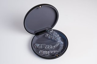 Clear Invisalign aligners lying in a black open case, representing orthodontic treatment options in Ontario