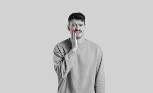 Man holding cheek with sinus tooth pain and upper jaw pressure discomfort